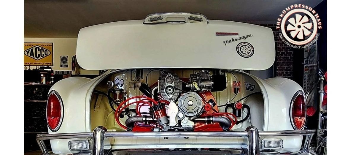 Cream Beetle with the decklid open, showing a supercharged engine with red
                    plug leads and polished pipework.